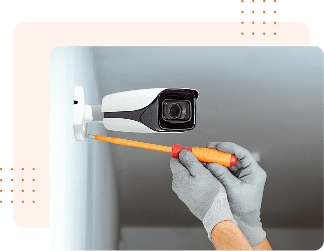 Hands adjusting wall-mounted camera