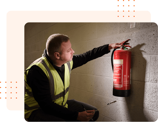Man inspecting wall-mounted fire extinguisher