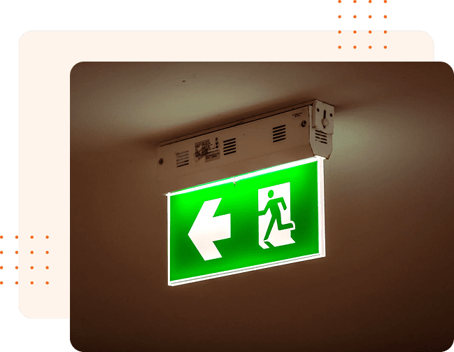 Glowing green emergency exit sign with a left-pointing arrow.