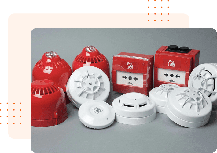 Various red and white fire alarm devices arranged on a surface.